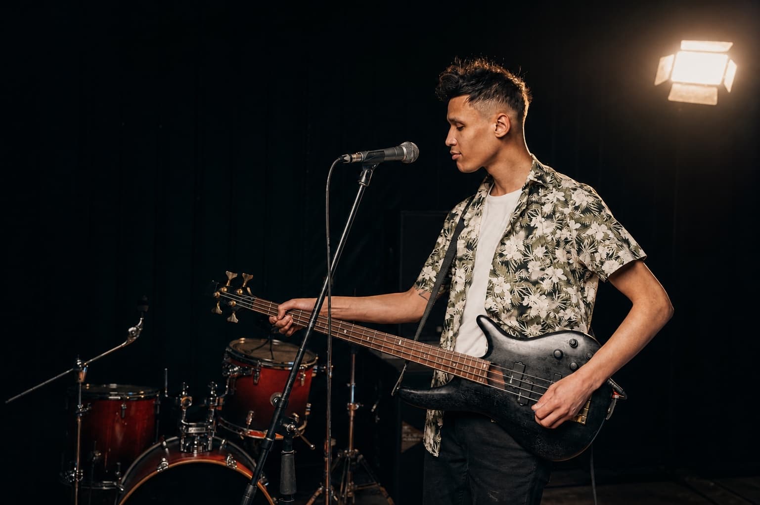 Bassist mit deutlich sichtbarem E-Bass im Musikstudio