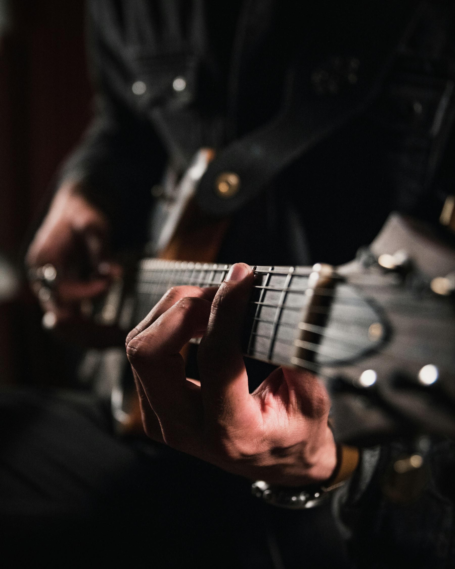 Nahaufnahme von Händen an einer akustischen Gitarre