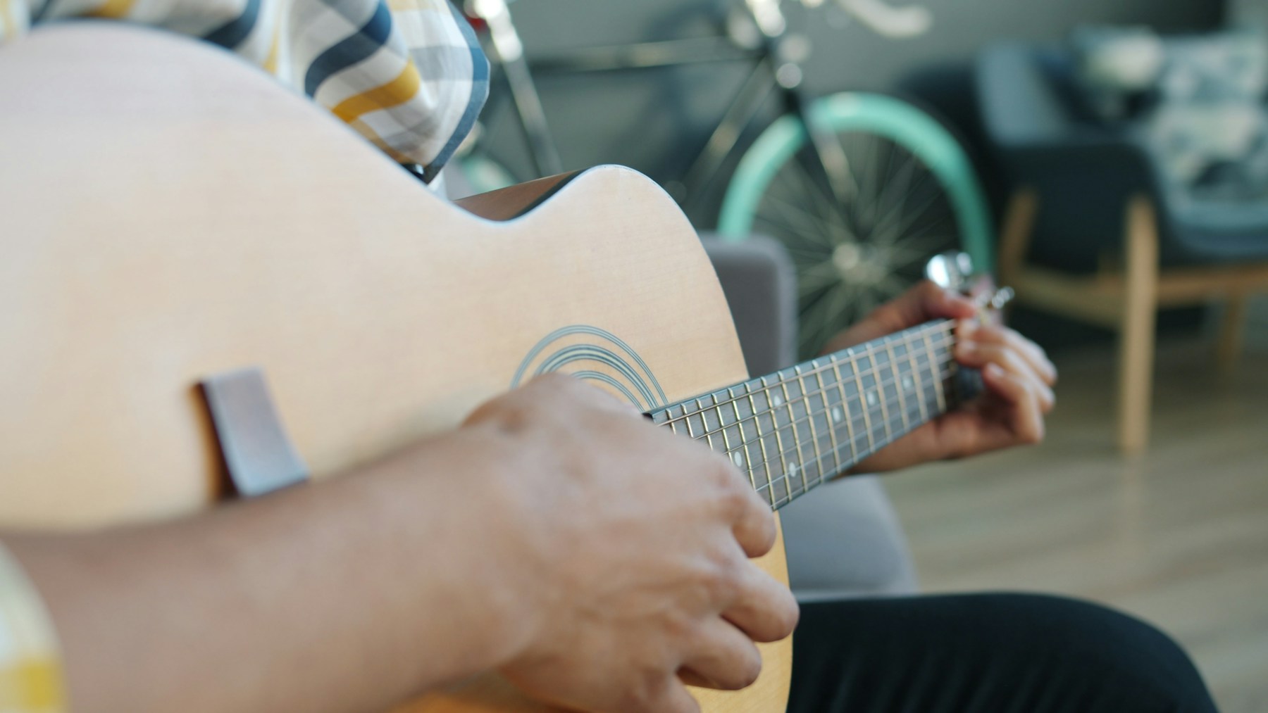 Person spielt zu Hause Gitarre – ruhig und persönlich