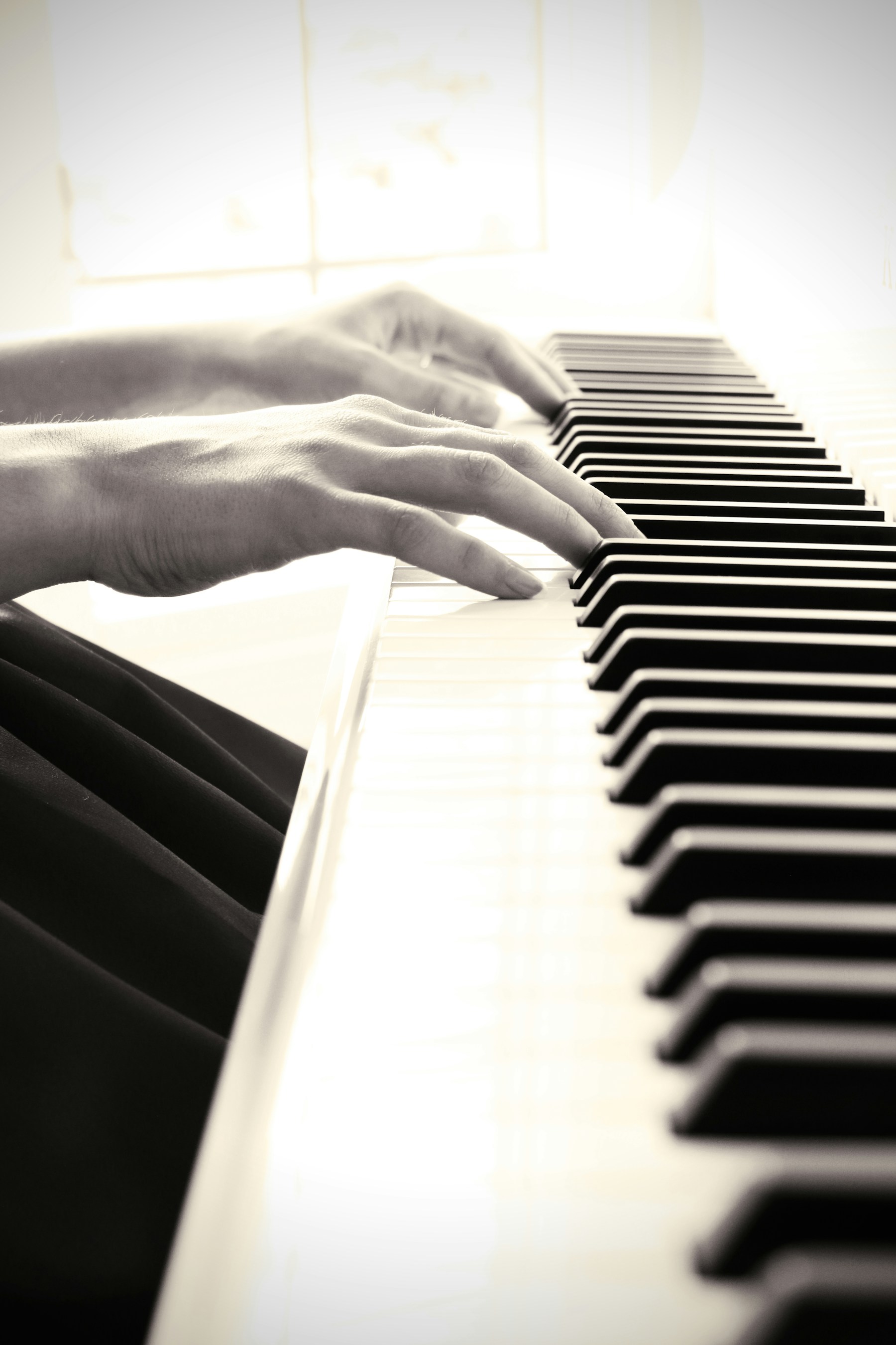 Hände spielen eine Klaviertastatur – ein Instrument praktisch ausprobieren